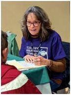 photo of linical nurse manager Julie Abramoff discussing the results of a heart health screening with a participant